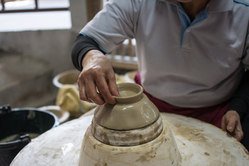 hands working clay on potter's wheel, Lampang in Thailand