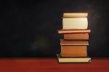 Back to school, pile of books with empty green school board background, education concept.