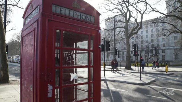 Close Up Of English Traditional Classic Telephone Red Booth , People Passing By Streets, Buildings Around, Everyday Life At London Uk , Traffic Light Streets, Trees At Autumn , B Roll