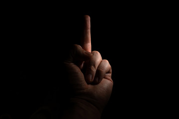 male hand with outstretched middle finger fak on a black background copy space. close up