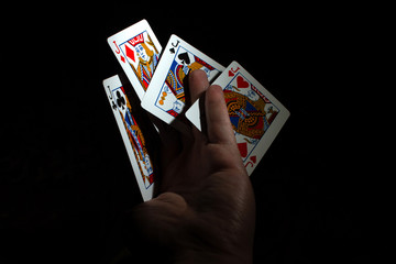 hand hold four jack of poker on black background copy space. close up