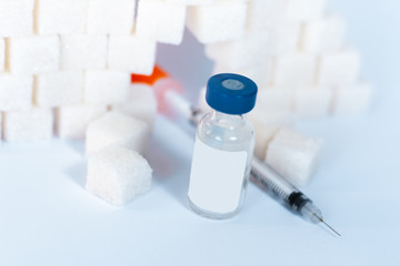 Sugar addiction, insulin resistance, unhealthy diet, sugar cubes pyramid, bottles of insulin and syringe for vaccination on white background, diabetes protection medical concept, top view.
