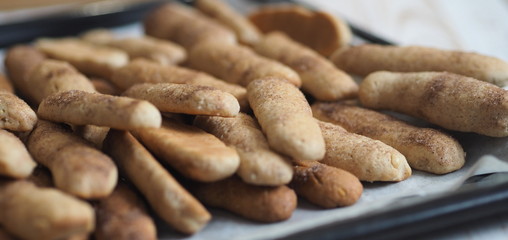 Homemade shortbread biscuits with cinnamon and nuts on a black baking sheet for the oven. We bake cookies.