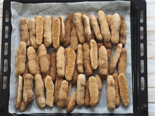Homemade shortbread biscuits with cinnamon and nuts on a black baking sheet for the oven. We bake cookies.