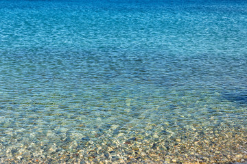 Waves with foam blue  sea on a sunny sandy beach in resort on summer vacation rest.