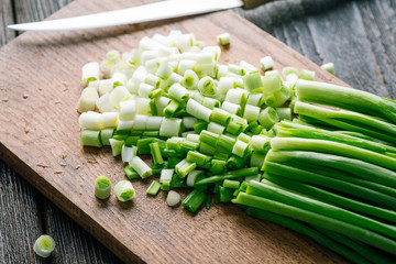 Sliced Fresh green onions on a wooden cutting board