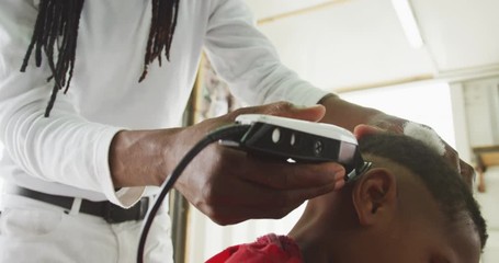 African man cutting African boy hair 