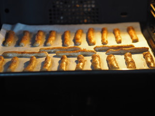 Homemade shortbread biscuits with cinnamon and nuts on a black baking sheet for the oven. We bake cookies.