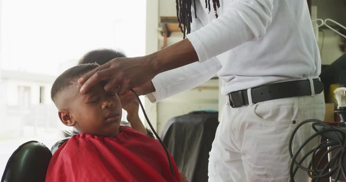 African man cutting African boy hair