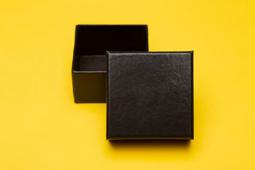 Mini black box product packaging isolated on yellow background.
