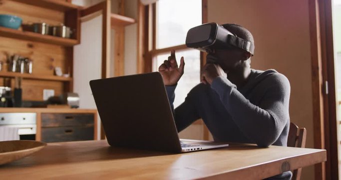 African American man wearing VR headset at home