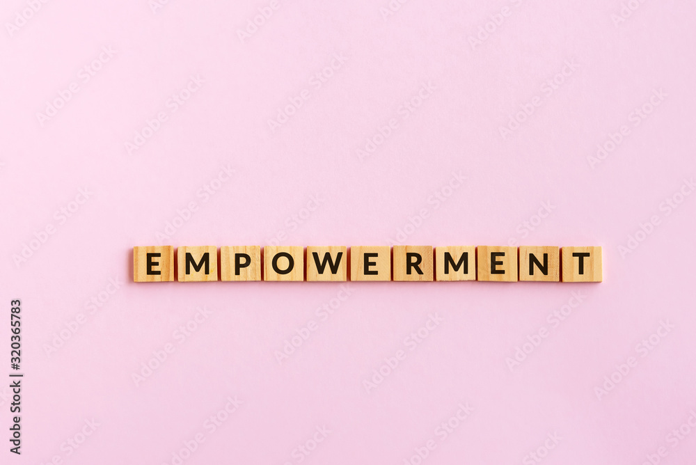 Wall mural empowerment text wood blocks. pink background.