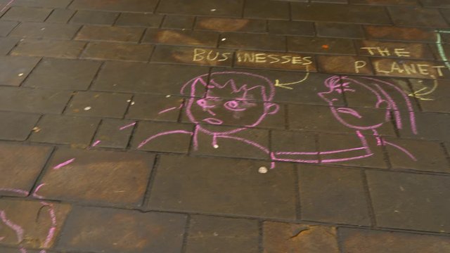 Climate Change Graffiti Meme written in Chalk in city Center Handheld Close Up