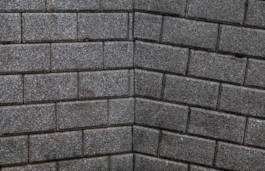 corner of a rectangular brick wall, which may lead to a break in the wall.