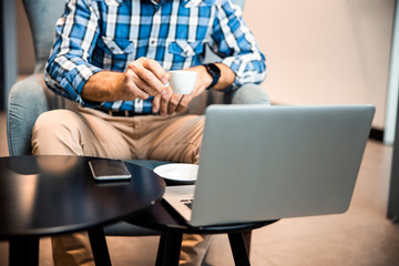 Male hand with cup of coffee in cafe
