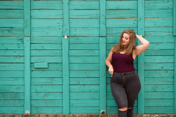 Young stylish woman walking in the city street. Spring fashion outfit, elegant look. Plus size...