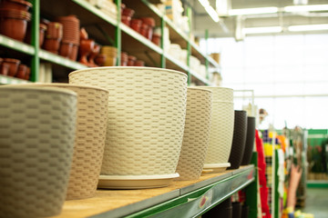 plastic flower pots, pots for indoor plants, garden tools store, shelves with flower pots
