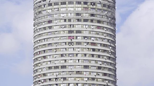 Ponte City Apartment building showing windows with curtains and satellite dish. Static. Closeup.