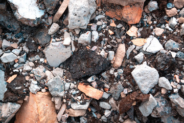 The broken brick on the construction site is white and red. Background with construction debris.