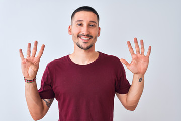 Young handsome man standing over isolated background showing and pointing up with fingers number...