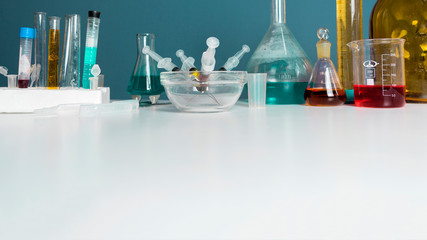 Lab desk. Test tubes small and big a white background. Copy Space.
