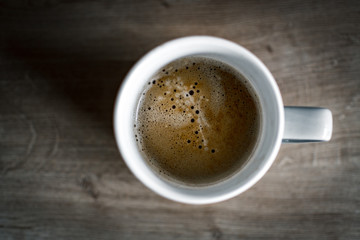 Coffee on a wood desk from above
