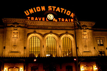 Union Station in Denver, Colorado at night as the sign is illuminated in orange and pierces the...