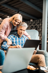 Happy mature woman is hugging her husband
