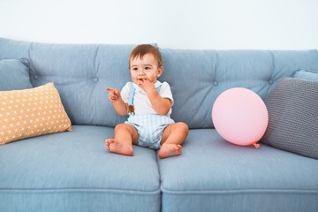 Adorable toddler sitting on the sofa at home