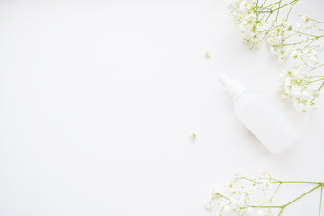 Beauty background cosmetic product, white flowers of gypsophila, on a  white, background of spring. flat lay, top view.