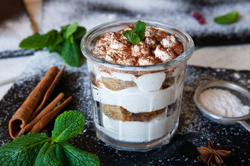 Tiramisu cake in glass, classic Italian dessert with mascarpone cream and cocoa. selective focus.