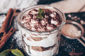 Tiramisu cake in glass, classic Italian dessert with mascarpone cream and cocoa. selective focus.