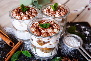 Tiramisu cake in glass, classic Italian dessert with mascarpone cream and cocoa. selective focus.