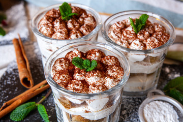 Tiramisu cake in glass, classic Italian dessert with mascarpone cream and cocoa. selective focus.