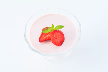 delicate strawberry ice cream with slices of strawberries with cream in a glass bowl on a light background, for advertising confectioners or sweets