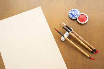 Top view of traditional chinese calligraphy tools on a wooden table.