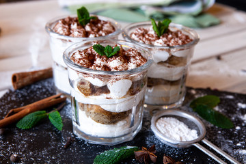 Tiramisu cake in glass, classic Italian dessert with mascarpone cream and cocoa. selective focus.