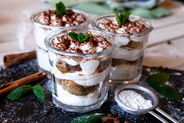 Tiramisu cake in glass, classic Italian dessert with mascarpone cream and cocoa. selective focus.