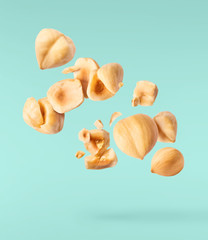 Fototapeta premium Hazelnuts crushed into pieces, frozen in the air.
