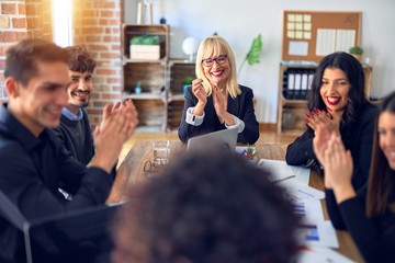 Group of business workers smiling happy and confident. Working together with smile on face applauding one of them at the office