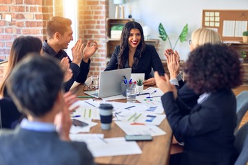Group of business workers smiling happy and confident. Working together with smile on face applauding one of them at the office