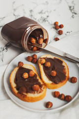 Jar of delicious chocolate paste on a marble white table