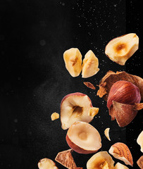 Hazelnuts crushed into pieces, frozen in the air.
