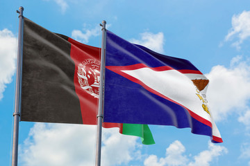 American Samoa and Afghanistan flags waving in the wind against white cloudy blue sky together. Diplomacy concept, international relations.