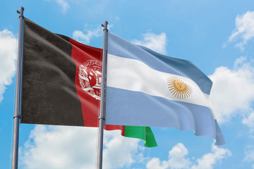 Argentina and Afghanistan flags waving in the wind against white cloudy blue sky together. Diplomacy concept, international relations.