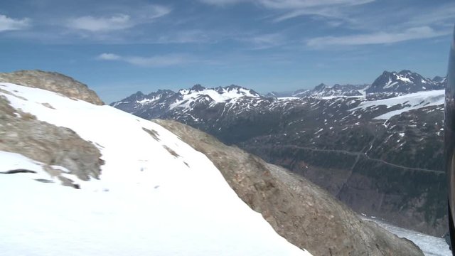AERIAL | Impressive glacier appears behind the peak of a mountain. Salmon Glacier in British Columbia.