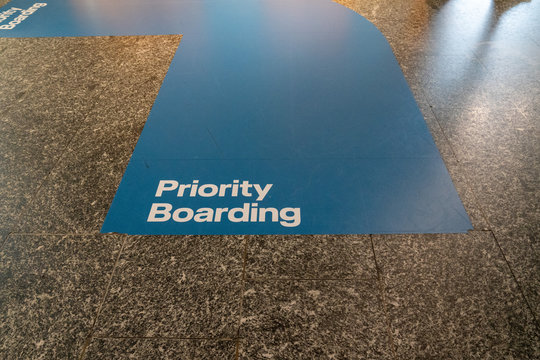 Blue Priority Boarding Lane Painted On Airport Terminal Floor Leading To Plane Boarding