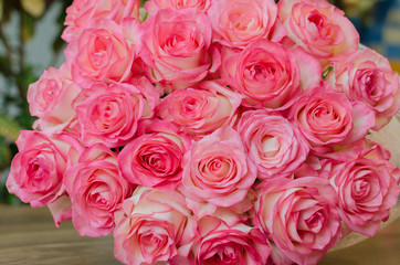 bouquet with delicate fragrant rose flowers on a wooden background, a gift for the holiday