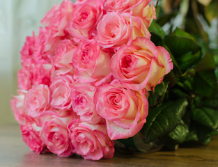 bouquet with delicate fragrant rose flowers on a wooden background, a gift for the holiday