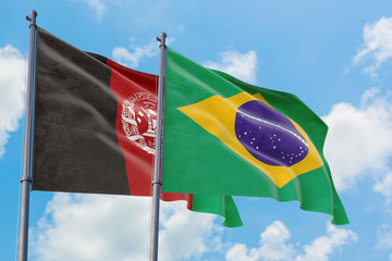 Brazil and Afghanistan flags waving in the wind against white cloudy blue sky together. Diplomacy concept, international relations.